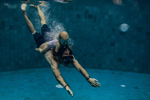 Padre e hija nadando juntos en la piscina