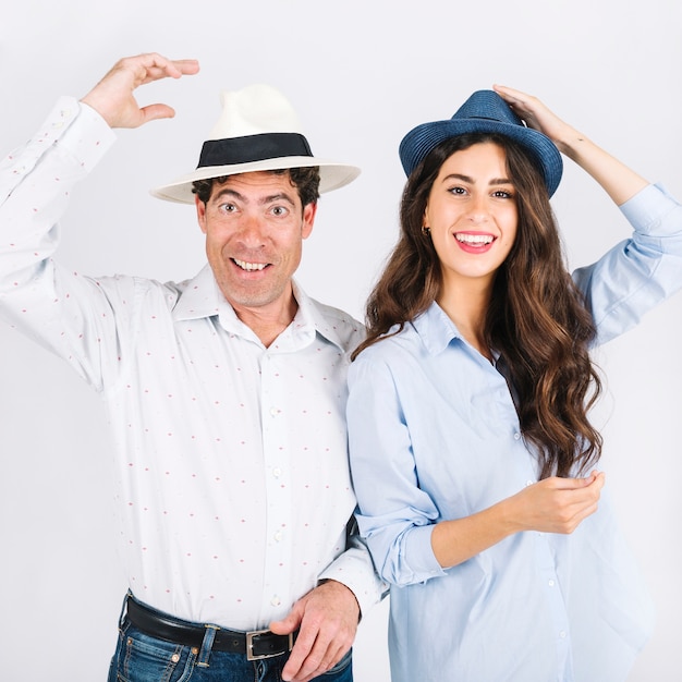 Padre e hija en sombreros mirando a cámara