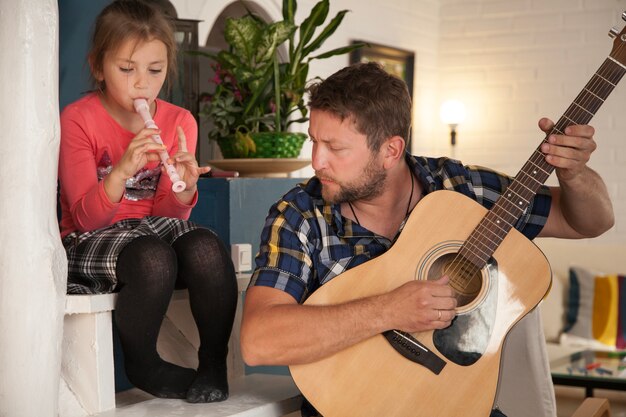 Padre e hija tocando instrumentos musicales
