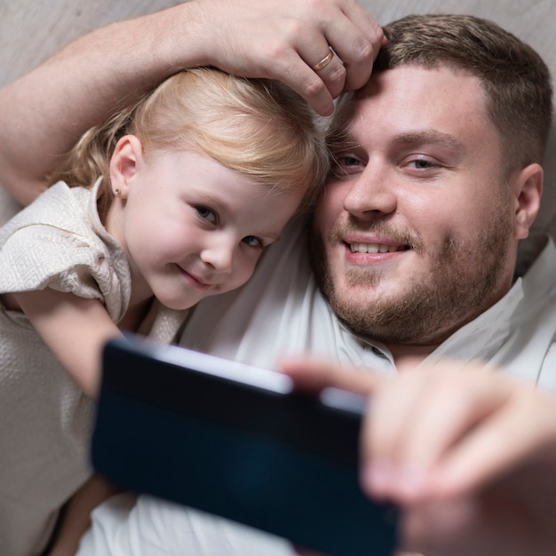 Padre e hija tomando selfie en casa