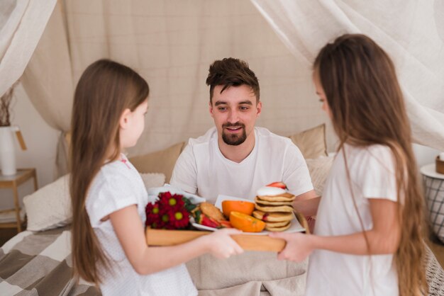 Padre e hijas desayunando en el día del padre