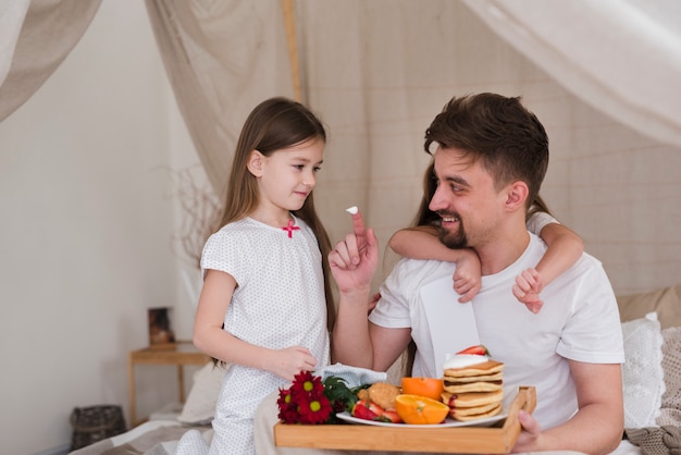 Padre e hijas desayunando en el día del padre