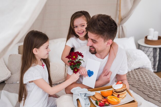 Padre e hijas desayunando en el día del padre