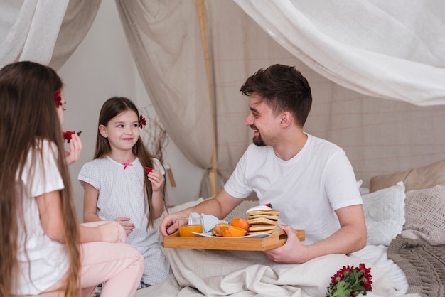 Padre e hijas desayunando en el día del padre