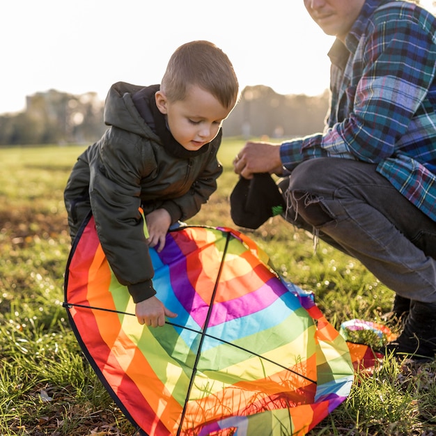 Foto gratuita padre e hijo arreglando una cometa