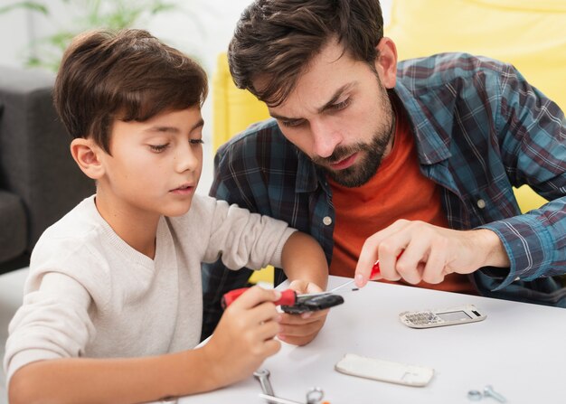 Padre e hijo arreglando un teléfono