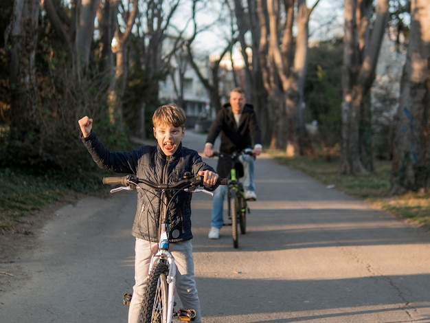 Padre e hijo en bicicleta en el parque