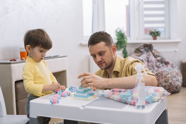 Padre e hijo construyendo juguetes a partir de piezas de lego