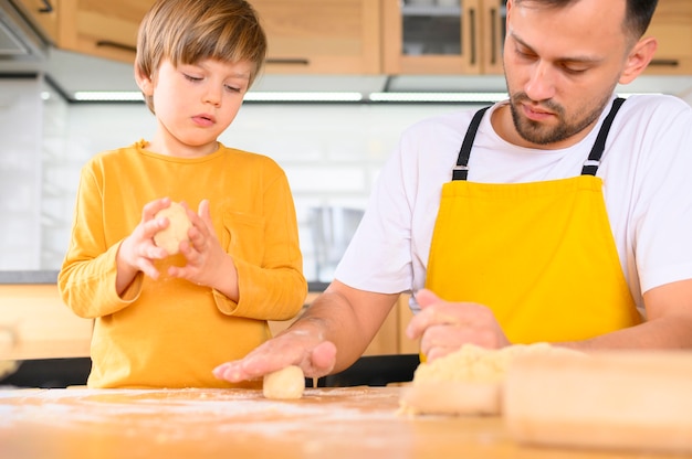 Padre e hijo creando bolas de masa de tiro medio