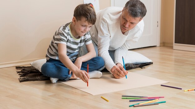 Padre e hijo dibujando con marcadores