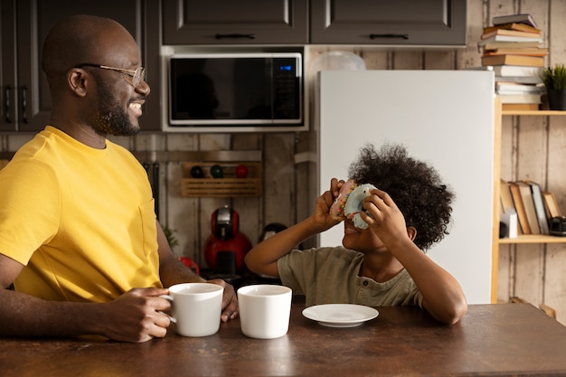 Foto gratuita padre e hijo con donuts juntos en la cocina