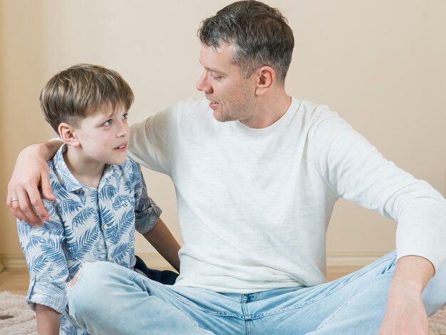 Padre e hijo hablando en el piso