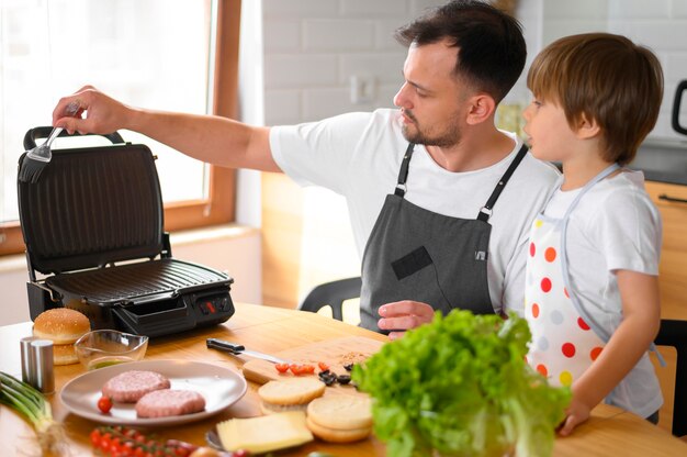 Foto gratuita padre e hijo haciendo una hamburguesa