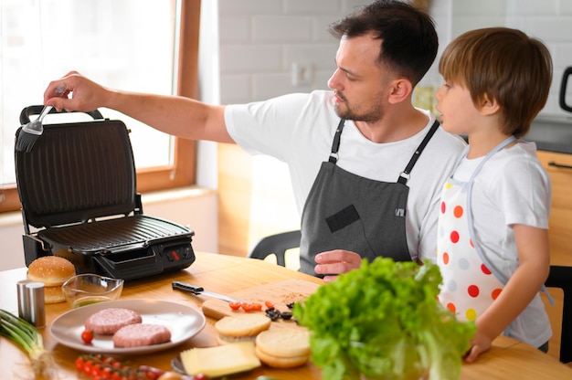 Padre e hijo haciendo una hamburguesa