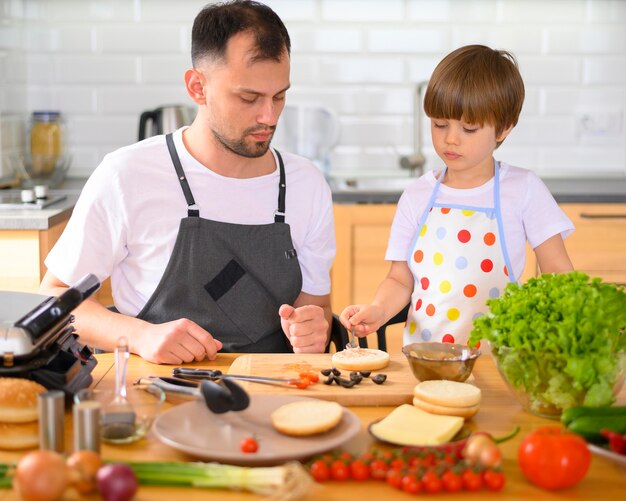 Padre e hijo haciendo una hamburguesa