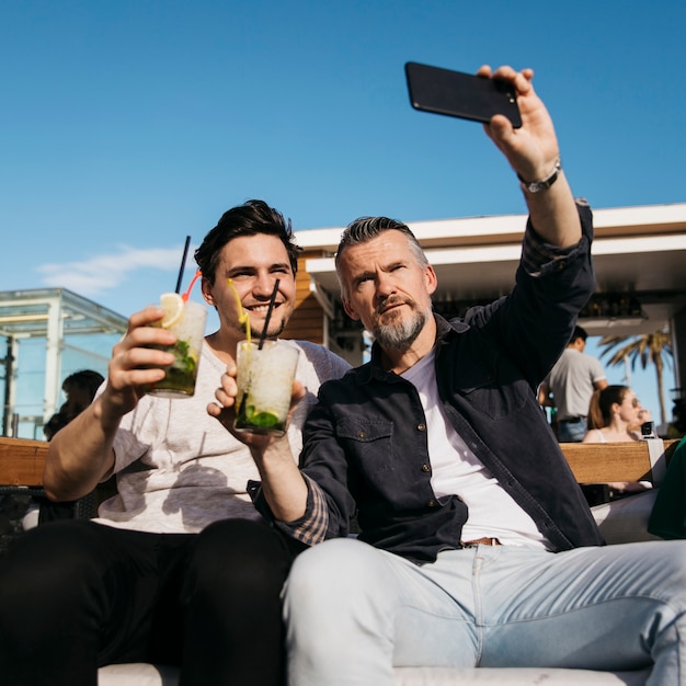 Padre e hijo haciendo selfie en bar