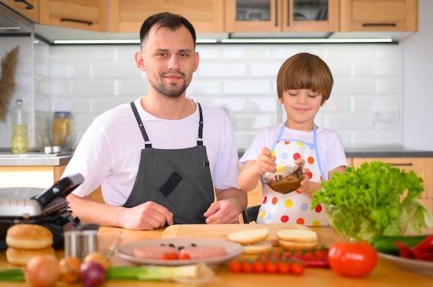 Padre e hijo haciendo una vista frontal de hamburguesas