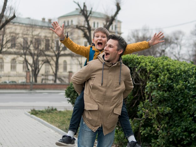 Padre e hijo jugando al lado de un parque