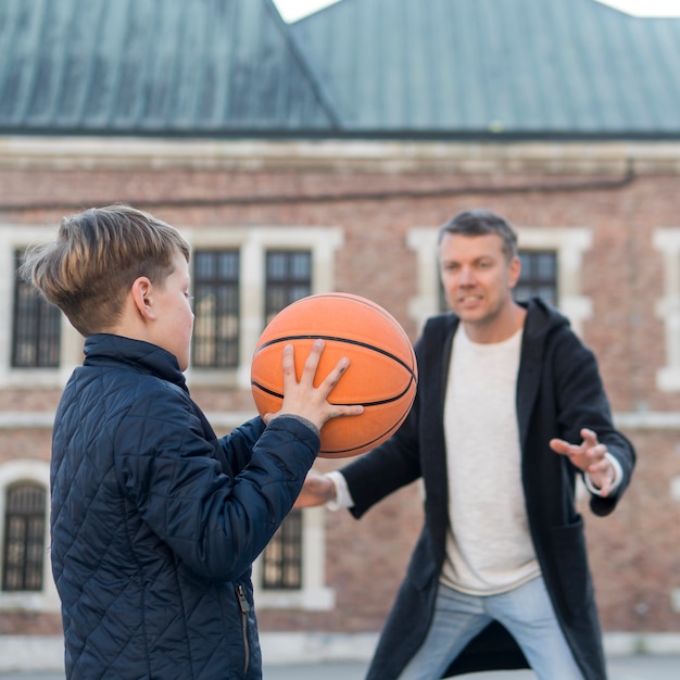 Foto gratuita padre e hijo jugando baloncesto al aire libre