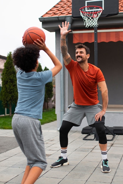 Padre e hijo jugando baloncesto juntos en el patio trasero