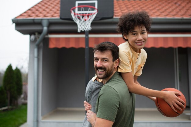 Padre e hijo jugando baloncesto juntos en el patio trasero