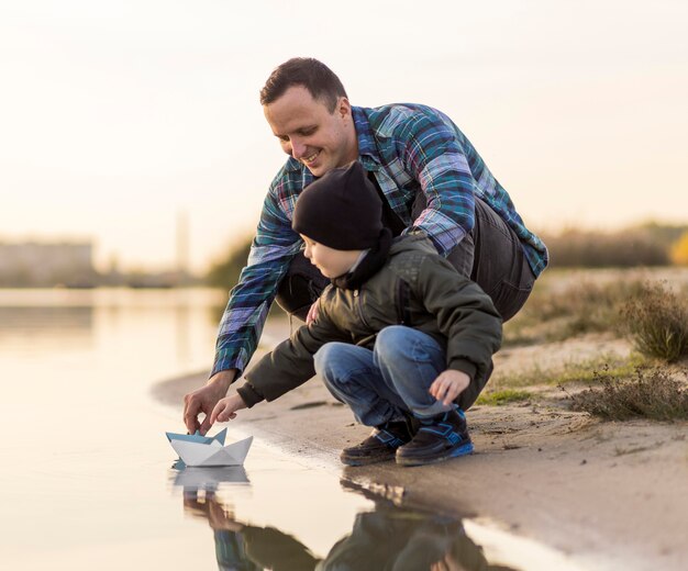 Padre e hijo jugando con un barco de origami