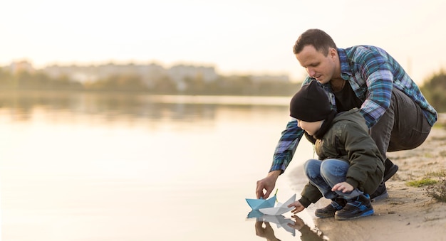 Padre e hijo jugando con un barco de papel