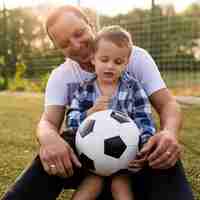 Foto gratuita padre e hijo jugando en el campo de fútbol