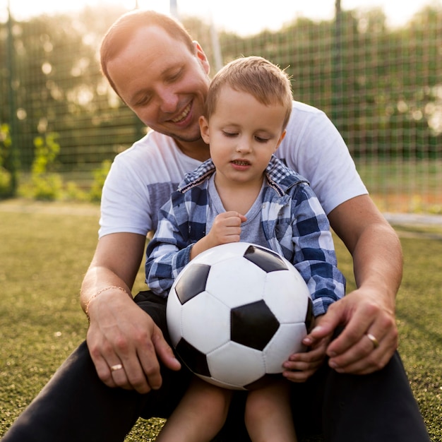 Padre e hijo jugando en el campo de fútbol