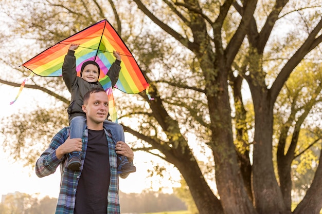 Foto gratuita padre e hijo jugando con una cometa