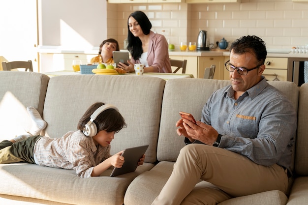 Padre e hijo jugando en sus dispositivos.