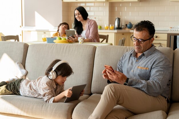 Padre e hijo jugando en sus dispositivos.