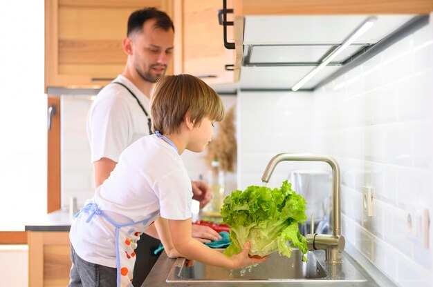 Padre e hijo, lavar la ensalada