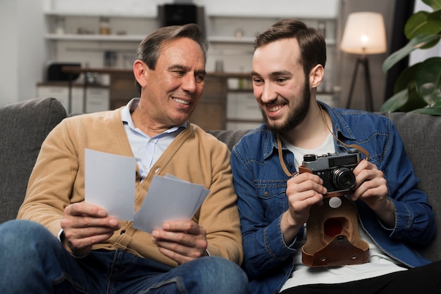 Padre e hijo mirando fotos en la sala de estar