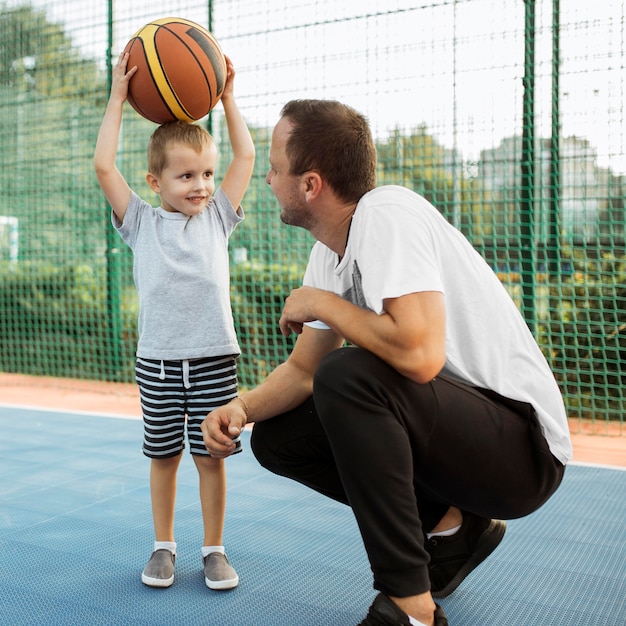 Padre e hijo pasando un buen rato en el campo de baloncesto