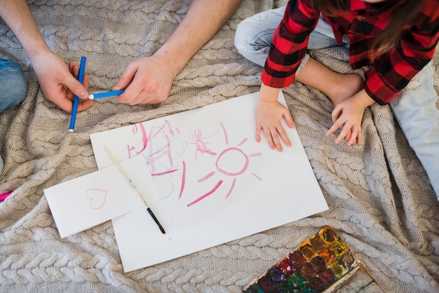 Padre e hijo pintando con ceras 