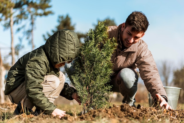 Foto gratuita padre e hijo, plantar un árbol