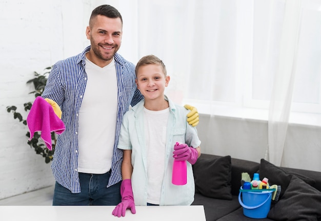 Padre e hijo posando mientras limpia la casa