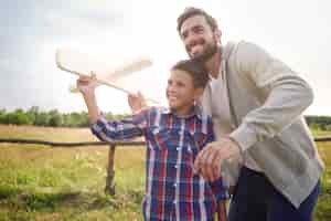 Foto gratuita padre e hijo probando un avión de papel