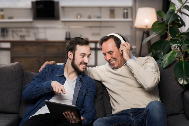 Padre e hijo riendo y mirando la tableta