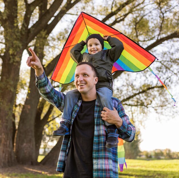 Padre e hijo sosteniendo una cometa en el parque