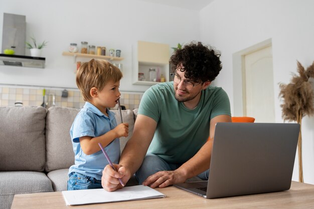 Foto gratuita padre e hijo de tiro medio en casa