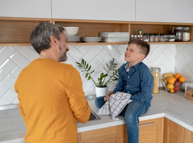 Padre e hijo de tiro medio en la cocina