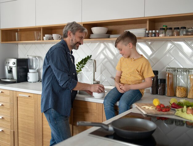 Foto gratuita padre e hijo de tiro medio cocinando