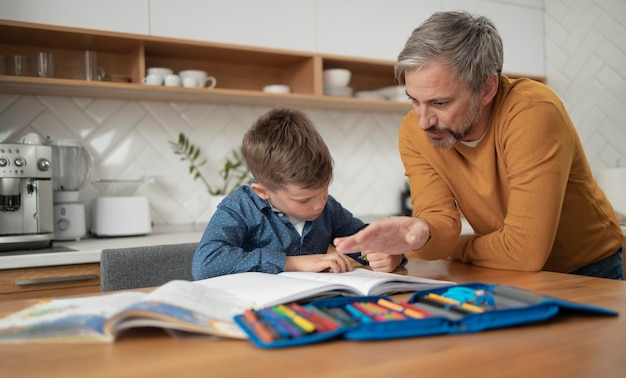 Padre e hijo de tiro medio haciendo los deberes