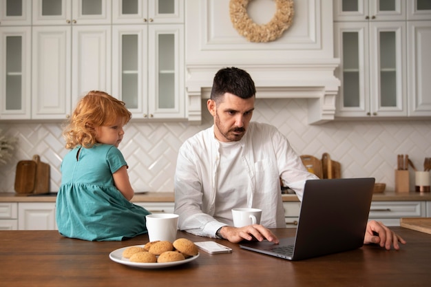 Foto gratuita padre e hijo de tiro medio con laptop