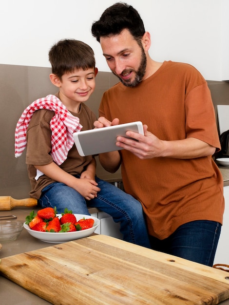 Foto gratuita padre e hijo de tiro medio con tableta