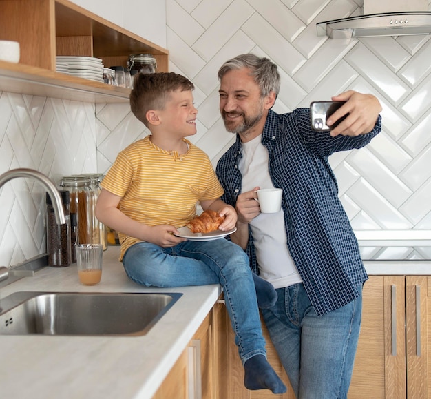 Padre e hijo de tiro medio tomando selfies