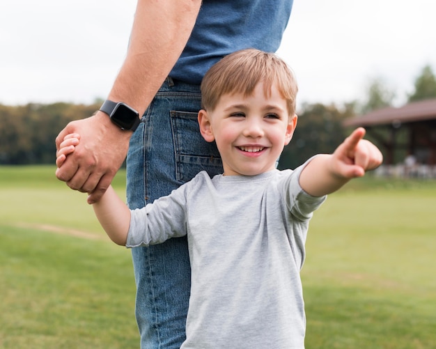 Foto gratuita padre e hijo tomados de la mano en el parque