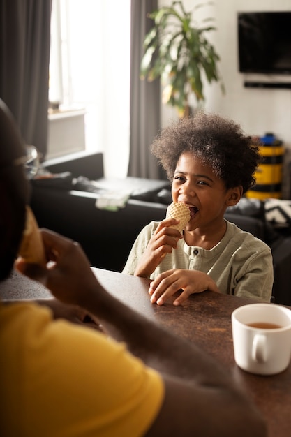 Padre e hijo tomando un helado juntos en la cocina